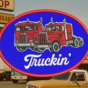 May include: Embroidered patch featuring two red semi-trucks on a blue oval background with a red border. The word "Truckin'" is written in white script below the trucks. The patch is set against a backdrop of a roadside restaurant.