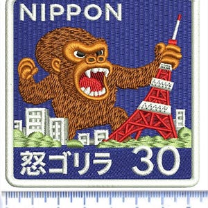May include: Embroidered patch with a blue background featuring the word "NIPPON" at the top. A brown gorilla is depicted holding a red Tokyo Tower. The Japanese text "怒ゴリラ 30" is at the bottom. The patch is approximately 2.5 inches wide.