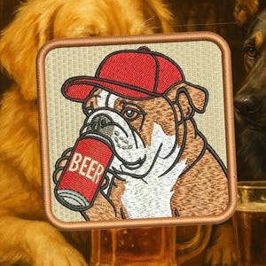 Op de afbeelding: Geborduurde patch met een bulldog met een rode pet en een bierblikje met het woord "BEER". De vierkante patch heeft een beige achtergrond en een bruine rand. Andere honden zijn op de achtergrond te zien.