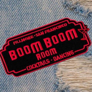 Puede incluir: Parche bordado negro y rojo con el texto "Boom Boom Room" y "Fillmore - San Francisco" y "Cocktails - Dancing" con un icono de copa de martini.