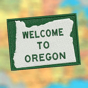 Puede incluir: Parche bordado verde con el contorno del estado de Oregón y el texto "Bienvenido a Oregón".