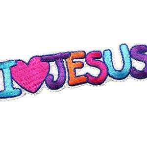 Op de afbeelding: Gestikt patch met de woorden "Ik hou van Jezus" in kleurrijke letters. Het woord "hou" wordt weergegeven door een roze hart.