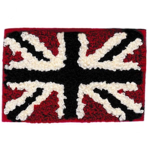 Könnte beinhalten: Ein roter, weißer und schwarzer Teppich mit einem Union-Jack-Muster. Der Teppich ist aus weichem, plüschigem Material gefertigt und perfekt, um jedem Raum einen Hauch von britischem Stil zu verleihen.