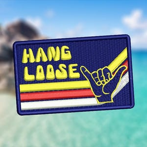 May include: A blue embroidered patch with yellow text that reads "HANG LOOSE" and a yellow, red, and white striped background. A blue hand with a yellow outline makes the "hang loose" gesture.