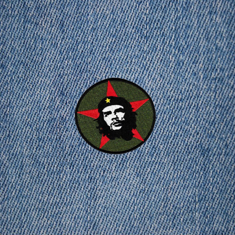 May include: A green and red embroidered patch with a stylized image of Che Guevara, a famous revolutionary, with a red star behind him.