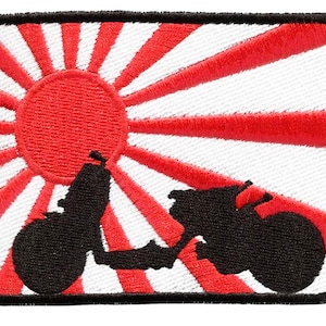 May include: A black and white embroidered patch with a silhouette of a scooter in front of a red and white rising sun design.