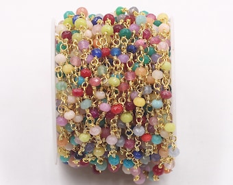 May include: A spool of gold chain with colorful gemstone beads. The chain is made of small, round beads and is perfect for making jewelry.