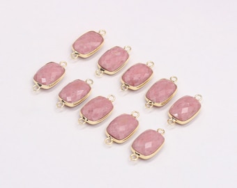 May include: Ten pink gemstone connectors with gold-colored metal frames. Each rectangular stone has a faceted surface and is connected to a small loop on each end. Ideal for jewelry making.