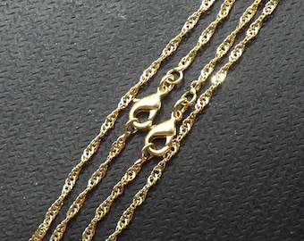 May include: Three gold chain necklaces with lobster claw clasps. The chains are twisted and have a shiny finish.