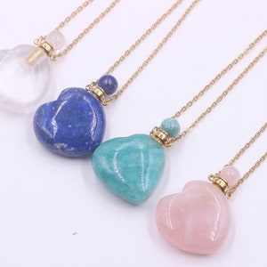 May include: Four gold heart-shaped necklaces with different colored gemstone pendants. The pendants are clear, blue, green, and pink.