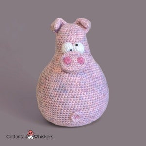 Op de afbeelding: Een roze gehaakt knuffelvarken met witte ogen en een roze snuit.