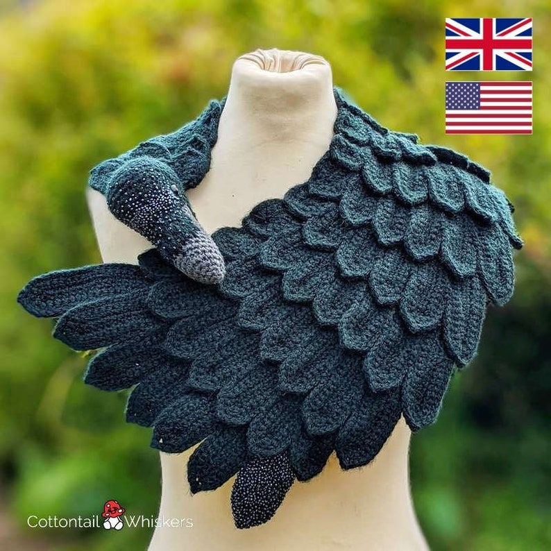 May include: A dark green crocheted scarf shaped like a bird's wing with a small crocheted bird head attached. The scarf is draped over a white mannequin.