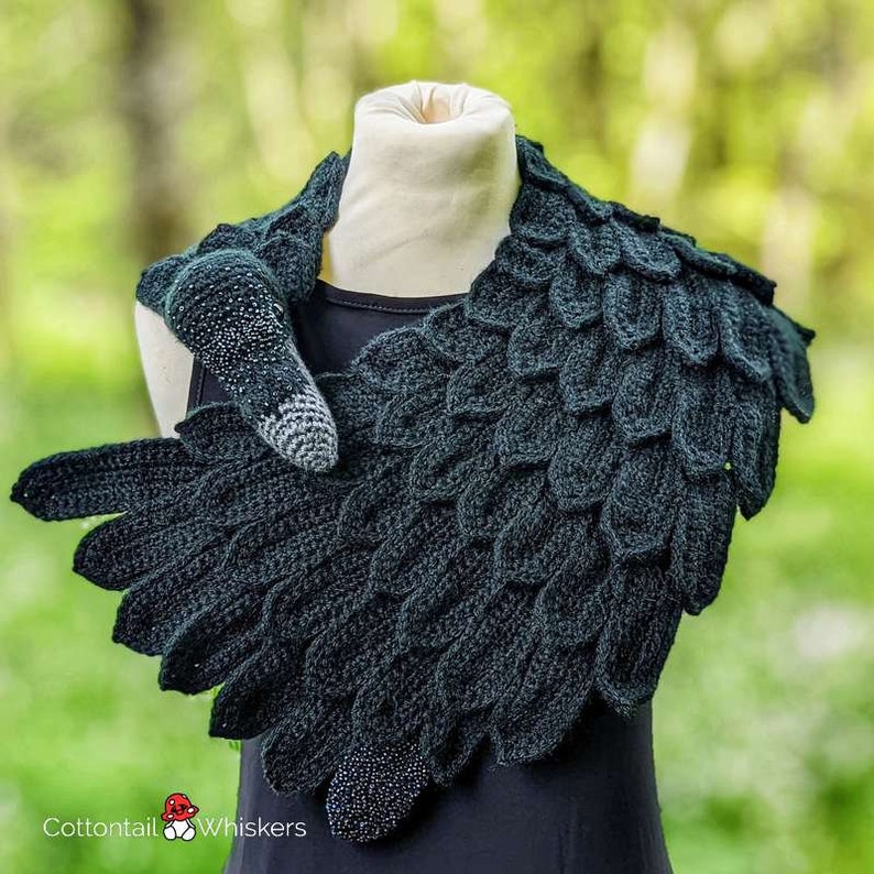 May include: A black crocheted scarf shaped like a swan's neck and wings. The scarf is decorated with black beads and has a 3D swan head.