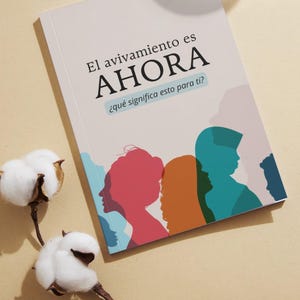 Könnte beinhalten: Ein Buch mit dem Titel "El avivamiento es AHORA" mit farbenfrohen Silhouetten von Menschen. Das Cover zeigt Text auf Spanisch und die Frage: "¿qué significa esto para ti?" Baumwollstiele mit weißen Blüten befinden sich im Vordergrund.