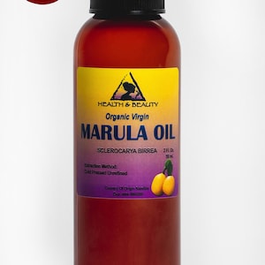 May include: A brown glass bottle with a black cap containing organic virgin marula oil. The label is yellow with purple text and features a small image of a tree. The label reads "Health & Beauty Organic Virgin Marula Oil Sclerocarya Birrea 2 fl. oz. 59 ml Extraction Method: Cold Pressed Unrefined Country of Origin Namibia Exp. date"