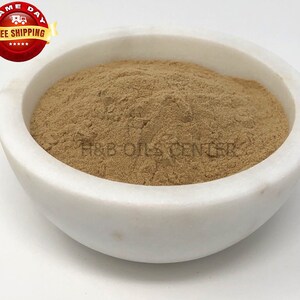 May include: A white ceramic bowl filled with a light brown powder. The powder is a natural ingredient used in herbal remedies.