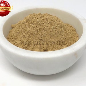 May include: A white ceramic bowl filled with a light brown powder. The powder is smooth and fine, and it appears to be a natural product.
