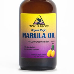May include: A brown glass bottle with a black cap, labeled "Organic Virgin Marula Oil" with the text "Sclerocarya Birrea 1 Fl. Oz 30 ml" and "Extraction Method: Cold Pressed Unrefined" and "Country Of Origin Namibia".
