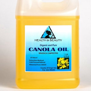 May include: A yellow plastic jug of organic and pure canola oil, labeled "Health & Beauty" with a triangle logo. The label also states "All Natural", "Extraction Method: Cold Pressed Refined", "Obtained from SEEDS", "Country of Origin Italy", "Exp. date", "7 LB. 3178 ml.", and features a small image of yellow canola flowers.