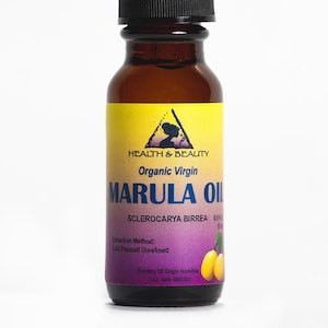 May include: A brown glass bottle with a black dropper top, labeled "Health & Beauty Organic Virgin Marula Oil Sclerocarya Birrea 0.5 fl oz 15 ml". The label also includes the extraction method, "Cold Pressed Unrefined", and the country of origin, "Namibia".