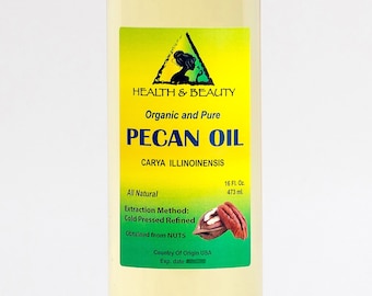 May include: A clear glass bottle with a white cap, containing pecan oil. The label is yellow and green with the text "HEALTH & BEAUTY", "Organic and Pure", "PECAN OIL", "CARYA ILLINOINENSIS", "All Natural", "Extraction Method: Cold Pressed Refined", "Obtained from NUTS", "Country of Origin USA", "Exp. date", and "16 FL. Oz. 473 ml.".