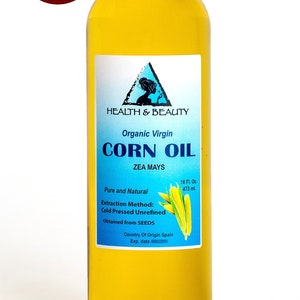 May include: A clear glass bottle of organic virgin corn oil with a blue and white label. The label says "Health & Beauty", "Organic Virgin Corn Oil", "Zea Mays", "Pure and Natural", "Extraction Method: Cold Pressed Unrefined", "Obtained from SEEDS", "Country of Origin Spain", and "16 Fl. Oz. 473 ml."
