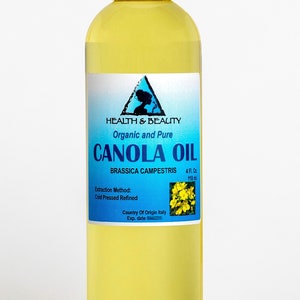 May include: A clear glass bottle with a white cap filled with yellow canola oil. The label is blue and white and reads "HEALTH & BEAUTY Organic and Pure CANOLA OIL BRASSICA CAMPESTRIS 4 FL. Oz. 118 ml. Extraction Method: Cold Pressed Refined Country Of Origin Italy Exp. date"