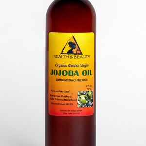 Puede incluir: Una botella de vidrio marr&oacute;n de aceite de jojoba virgen dorado org&aacute;nico. La etiqueta es amarilla con un tri&aacute;ngulo negro y las palabras "HEALTH & BEAUTY" y "JOJOBA OIL". La botella es de 8 onzas l&iacute;quidas o 237 mililitros.
