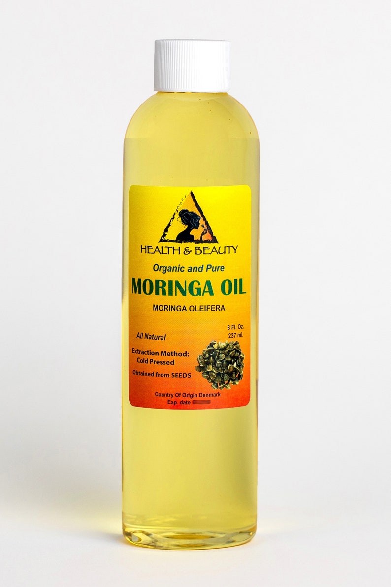 May include: A clear glass bottle with a yellow label containing 8 fluid ounces of organic and pure Moringa Oil. The label features a triangle with a woman's silhouette inside, the words "Health & Beauty", and the text "Moringa Oil Moringa Oleifera". The label also states that the oil is all natural, cold pressed, obtained from seeds, and made in Denmark.
