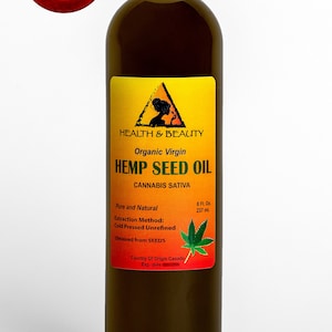 May include: A glass bottle of organic virgin hemp seed oil, labeled "HEALTH & BEAUTY", with a yellow triangle and a black silhouette of a woman. The bottle is 8 fluid ounces (237 ml) and is labeled "Pure and Natural", "Cold Pressed Unrefined", "Obtained from SEEDS", "Country of Origin Canada", and "Exp date".