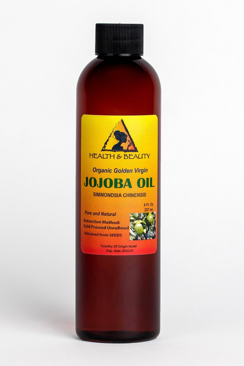 Puede incluir: Una botella de vidrio marr&oacute;n de aceite de jojoba virgen dorado org&aacute;nico. La etiqueta es amarilla con texto negro y una silueta de una mujer. La etiqueta dice "HEALTH & BEAUTY Organic Golden Virgin JOJOBA OIL SIMMONDSIA CHINENSIS Pure and Natural Extraction Method: Cold Pressed Unrefined Obtained from SEEDS Country Of Origin Israel Exp. date 8 Fl. Oz. 237 ml."