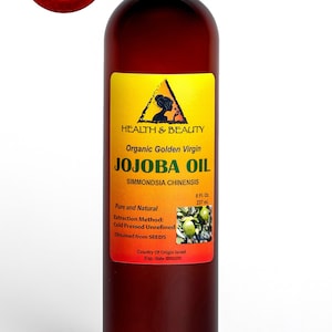 Puede incluir: Una botella de vidrio marr&oacute;n de 237 ml de aceite de jojoba virgen dorado org&aacute;nico. La etiqueta amarilla tiene texto negro y una peque&ntilde;a imagen de la cara de una mujer. La etiqueta dice "Health & Beauty Organic Golden Virgin Jojoba Oil Simmondsia Chinensis Pure and Natural Extraction Method: Cold Pressed Unrefined Obtained from SEEDS Country of Origin Israel Exp. date"