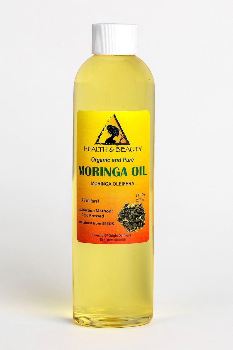 May include: A clear glass bottle with a yellow label containing 8 fluid ounces of organic and pure Moringa Oil. The label features a triangle with a silhouette of a woman and the text "HEALTH & BEAUTY". The label also includes the text "Moringa Oleifera" and "Extraction Method: Cold Pressed".