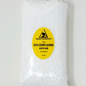 May include: A clear plastic bag filled with white beads. The bag has a yellow label with a black triangle and the text "HEALTH & BEAUTY Pure CETYL-STEARYL ALCOHOL RSPO MB No Additives 16 oz".