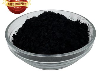 May include: A glass bowl filled with black powder. The powder is a fine, dark black color and appears to be evenly distributed throughout the bowl.