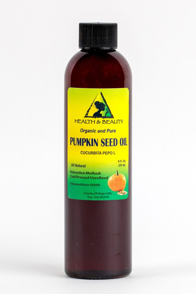 May include: A brown glass bottle with a black cap containing 8 fluid ounces (237 ml) of organic and pure pumpkin seed oil. The label is yellow with green text and a green triangle containing a silhouette of a woman. The label reads "HEALTH & BEAUTY", "Organic and Pure", "PUMPKIN SEED OIL", "CUCURBITA PEPO L", "All Natural", "Extraction Method: Cold Pressed Unrefined", "Obtained from SEEDS", "Country of Origin USA", "Exp. date". A small image of a pumpkin is on the label.