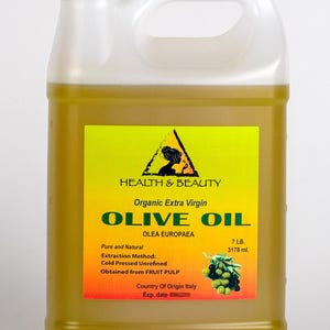 Op de afbeelding: Een gallonkan van biologische extra vierge olijfolie, met het label "HEALTH & BEAUTY Biologische extra vierge olijfolie OLEA EUROPAEA Puur en natuurlijk Extractiemethode: Koudgeperst ongeraffineerd Verkregen uit FRUITPULP Herkomstland Itali&euml; Exp. datum 7 LB. 3178 ml."