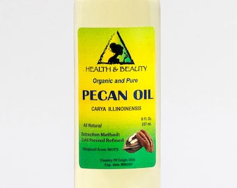 May include: A clear glass bottle with a white cap, containing pecan oil. The label is yellow with green text and a green triangle with a silhouette of a woman inside. The label reads "Health & Beauty Organic and Pure Pecan Oil Carya Illinoinensis" and includes information about the oil, such as "All Natural", "Extraction Method: Cold Pressed Refined", "Obtained from NUTS", "Country of Origin USA", and "Exp. date".