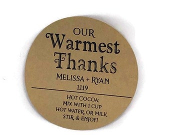 May include: A brown paper circle sticker with the text "OUR Warmest Thanks MELISSA + RYAN 1.1.19 HOT COCOA: MIX WITH 1 CUP HOT WATER, OR MILK STIR, & ENJOY!"