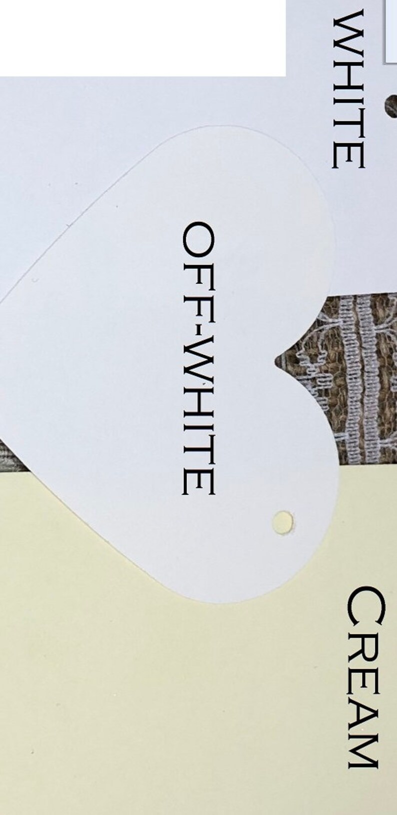 May include: Two paint colour swatches, one labelled "WHITE" and the other labelled "OFF-WHITE" in a heart shape. The swatches are on a cream background.