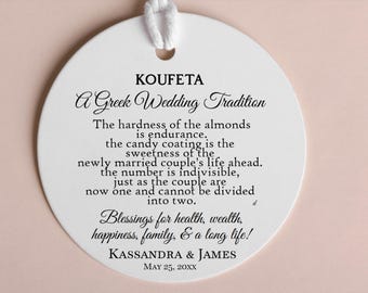 May include: White round ornament with black text that reads "KOUFETA A Greek Wedding Tradition" and explains the meaning of the tradition. The ornament also includes the names "KASSANDRA & JAMES" and the date "MAY 25, 20XX".