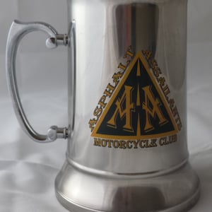 May include: A silver metal beer stein with a black and gold logo that says "Asphalt Assailants Motorcycle Club".