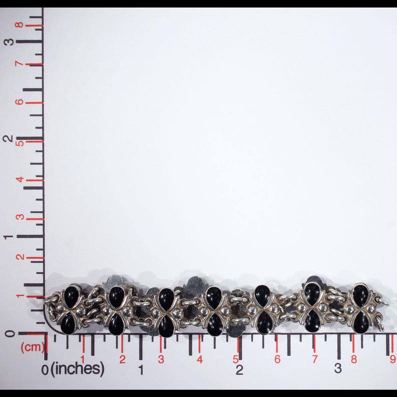 Pu&ograve; includere: Un braccialetto d'argento con pietre nere, che misura circa 19 cm di lunghezza.