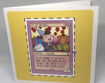 May include: A square greeting card with a yellow border featuring a game card illustration titled IT'S MY BIRTHDAY! The card shows a cartoon character in a party hat surrounded by gifts and cake, with text describing cake tokens and presents.