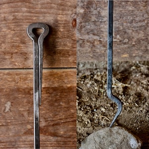 May include: Two metal fireplace tools. The first tool is a poker with a rounded top and a long, straight shaft. The second tool is a hook with a curved end and a long, straight shaft.