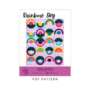 May include: A PDF pattern for a quilt called "Rainbow Sky". The quilt features a colorful design of rainbows and clouds on a light purple background. The pattern is a modern quilt pattern and is available for download.
