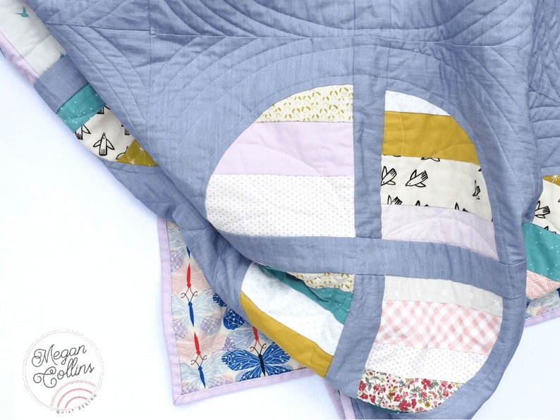 May include: A blue and white patchwork quilt with a variety of patterns, including polka dots, stripes and floral prints. The quilt is folded in half and the edges are visible.