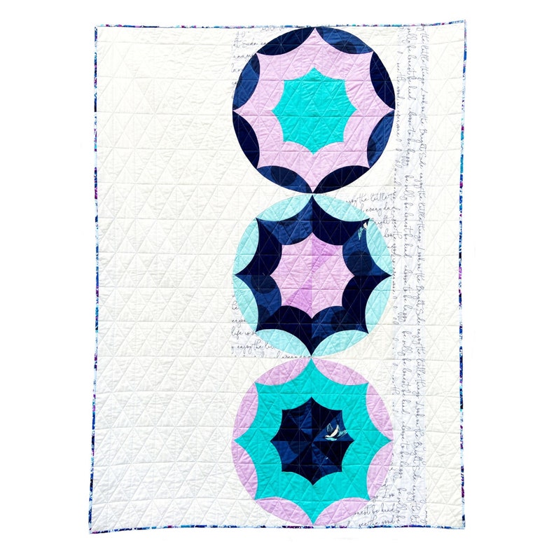 Puede incluir: Una colcha blanca con tres c&iacute;rculos conc&eacute;ntricos en tonos rosa, turquesa y azul marino. Los c&iacute;rculos tienen un patr&oacute;n de estrella con fondo blanco.