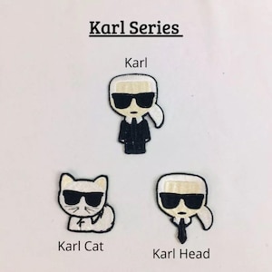 Peut inclure: Trois patchs thermocollants représentant un personnage de dessin animé avec des lunettes de soleil noires et une chemise blanche. Les patchs sont étiquetés "Karl", "Karl Cat" et "Karl Head".