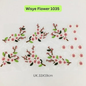 May include: Embroidered floral appliques featuring pink and white blossoms, green leaves, and brown stems. The text "Wisye Flower 1035" is displayed. The dimensions are 13 x 7.5 inches.